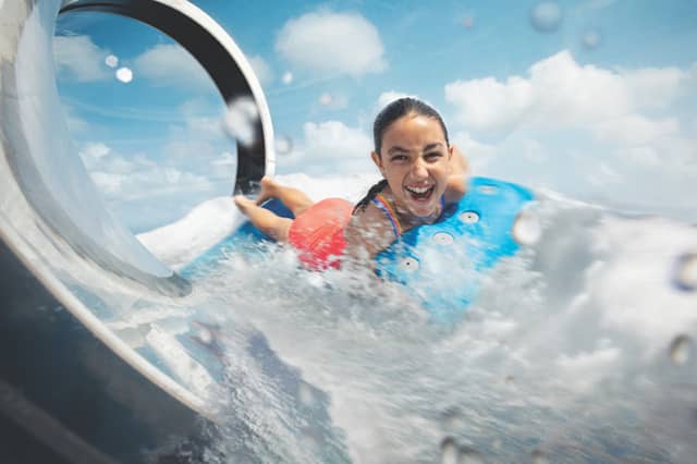 What to expect on Royal Caribbean in 2022 - JJ Travel Associates - Best Travel Agents in NJ Young woman laughing on a water slide