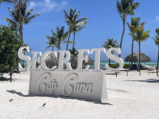 secrets-sign - JJ Travel Associates - Best Travel Agents in NJ Secrets Cap Cana sign on the beach