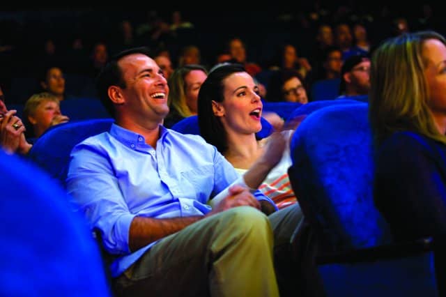 \"ncl_Entmnt_Audience_Laugh Couple having fun at the theater on Getaway