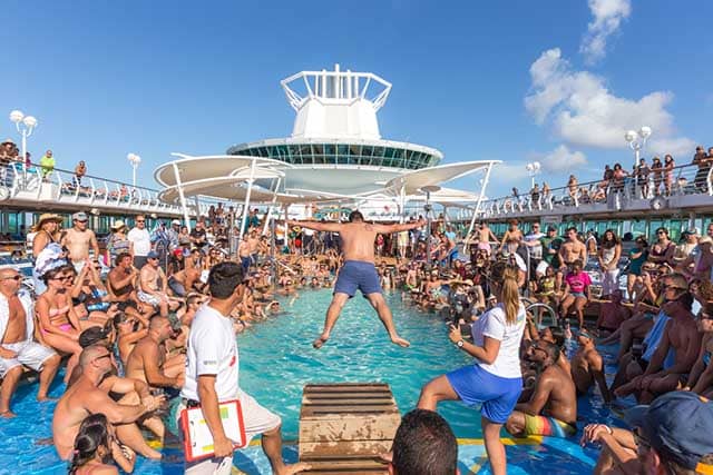pool-deck - JJ Travel Associates - Best Travel Agents in NJ Man belly flopping into the pool to wild cheers and applause