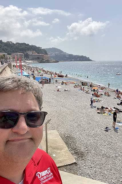 joel-nice-beach - JJ Travel Associates - Best Travel Agents in NJ Joel at a rocky beach in Nice